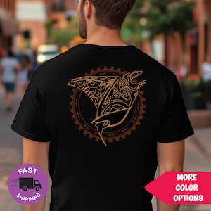May include: Black t-shirt with a brown manta ray design on the back, featuring detailed patterns within a circular border. The shirt has a crew neck and short sleeves. The image also includes a "More Color Options" button.