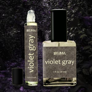 Puede incluir: Se muestran dos frascos de perfume con el texto "Violet Gray". Uno es un frasco roll-on y el otro es un frasco rociador rectangular. El frasco roll-on est&aacute; etiquetado como .33 fl oz (10 ml), y el frasco rociador est&aacute; etiquetado como 30 ml.