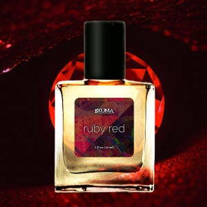 May include: A square perfume bottle with a black cap and a label that reads "ruby red". The label has the text "EXUMA FRAGRANCE CO." and "1 fl oz (30 ml)". The background is a dark red with a ruby-like design.