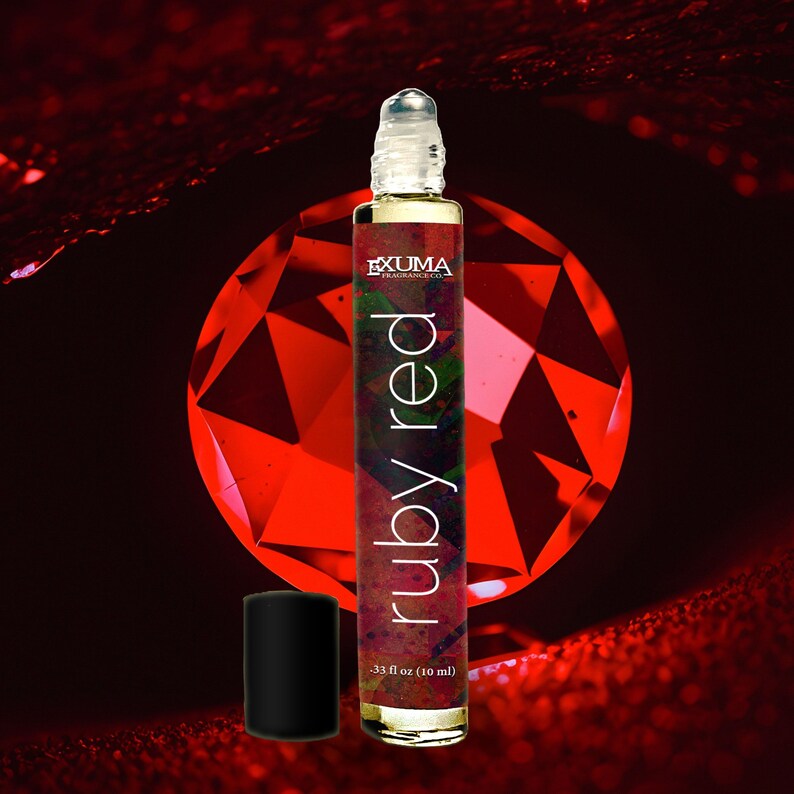 May include: A roll-on perfume bottle with the text "ruby red" and "EXUMA Fragrance Co." against a red background. The bottle is .33 fl oz (10 ml) and has a black cap.