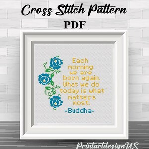 May include: A framed cross-stitch pattern with the text "Each morning we are born again. What we do today is what matters most. -Buddha-". The design includes blue floral accents and the words "Cross Stitch Pattern PDF".