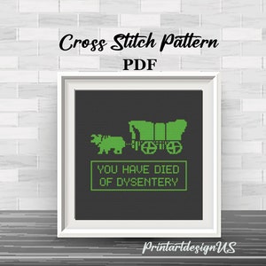 May include: Cross stitch pattern PDF of a green pixelated wagon and ox with the text "You Have Died of Dysentery" on a black background.
