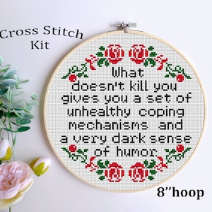 May include: Cross stitch kit featuring a white hoop with a red and green floral design and the text "What doesn't kill you gives you a set of unhealthy coping mechanisms and a very dark sense of humor". The hoop is 8 inches in diameter.