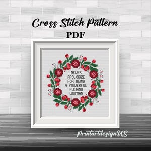 May include: A framed cross-stitch pattern with the text "NEVER APOLOGIZE FOR BEING A POWERFUL FUCKING WOMAN" surrounded by a floral wreath. The words "Cross Stitch Pattern PDF" are at the top. The frame is white.