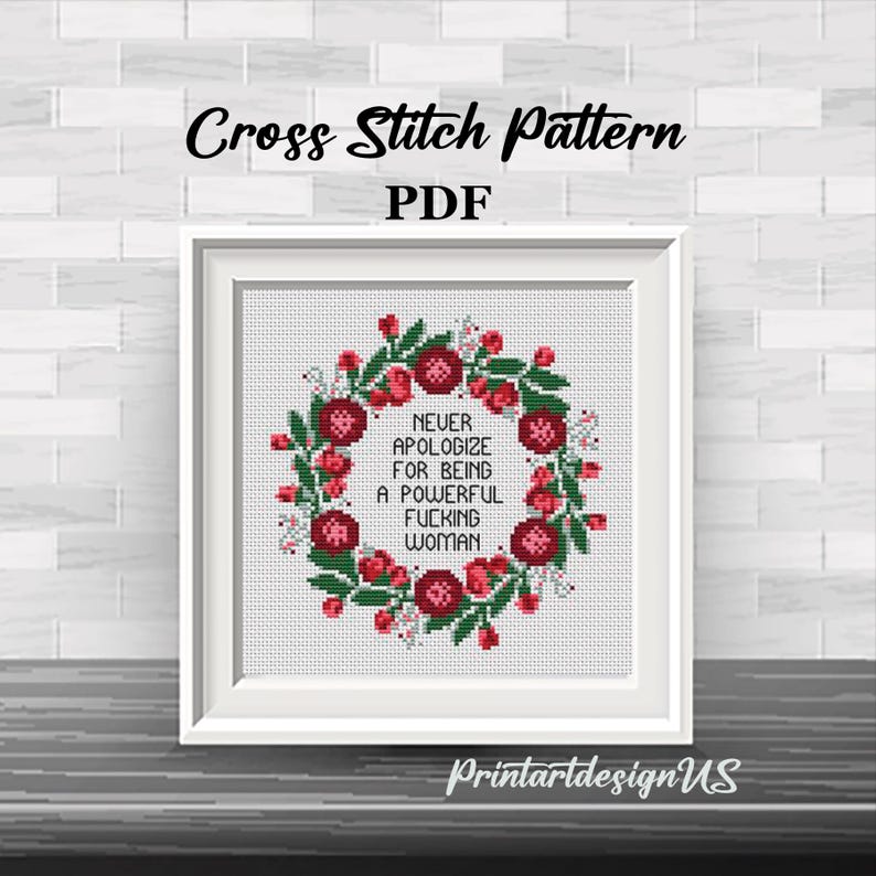 May include: A framed cross-stitch pattern with the text "NEVER APOLOGIZE FOR BEING A POWERFUL FUCKING WOMAN" surrounded by a floral wreath. The words "Cross Stitch Pattern PDF" are at the top. The frame is white.