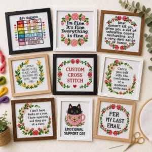 Könnte beinhalten: Eine Sammlung gerahmter Kreuzstich-Stickereien mit verschiedenen Zitaten und Designs. Die Stickereien weisen florale Ränder und humorvolle oder ermächtigende Texte auf, darunter "Gay Agenda" und "Emotional Support Cat."