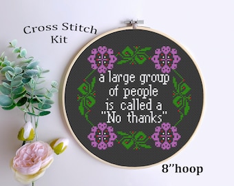 May include: Cross stitch kit featuring a black embroidery hoop with a dark grey background. The hoop has a purple floral design with green leaves and the text "a large group of people is called a "No thanks"". The hoop is 8 inches in diameter.