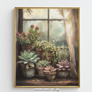 May include: A framed painting of potted succulents and other plants on a windowsill. The painting has a soft, muted color palette with shades of green, pink, and brown. The window is visible in the background, with a curtain on the right side. The painting is signed "Moonhaven Designs".
