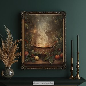 May include: A framed painting depicts a steaming cauldron with apples, holly, and berries. The artwork has a warm, inviting color palette with a vintage aesthetic. The frame is ornate, and the scene evokes a cozy, autumnal atmosphere.