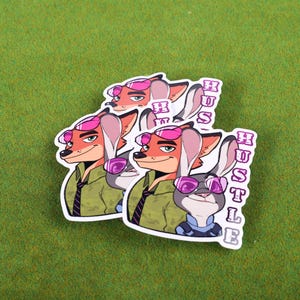 May include: Two stickers featuring cartoon characters from the movie Zootopia. The characters are a fox and a rabbit wearing sunglasses. The stickers have the word "Hustle" written vertically on them.