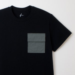 May include: A black short-sleeved t-shirt with a large, dark green utility pocket on the left side.