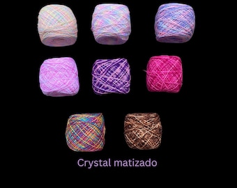 May include: Assortment of colorful yarn balls in various shades of pink, purple, brown, and blue. The yarn is labeled "Crystal matizado" and "Mirilena's Supplies".