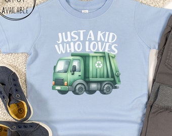May include: Light blue t-shirt with a green garbage truck graphic and the text "Just a kid who loves".