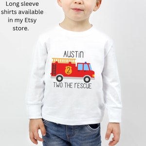 Puede incluir: Una camiseta blanca de manga larga con un gr&aacute;fico de un cami&oacute;n de bomberos rojo con una escalera amarilla, una insignia amarilla con el n&uacute;mero 2 y el texto AUSTIN y TWO THE RESCUE. El texto Long sleeve shirts available in my Etsy store aparece arriba.