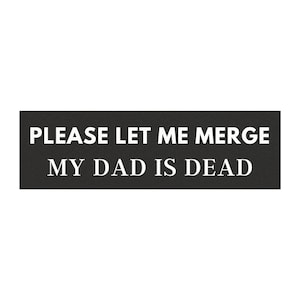 May include: A rectangular black sign with white text that reads "PLEASE LET ME MERGE" above "MY DAD IS DEAD". The sign is against a white background.