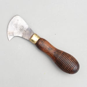 Könnte beinhalten: Ein Vintage-Messer mit gebogener Klinge und Holzgriff. Die Metallklinge trägt den Stempel "J. DIXON". Der Griff ist dunkelbraun mit einer Messingzwinge. Das Messer ist zum Schneiden bestimmt.