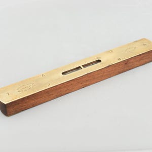以下が含まれることがあります： 木製のボディと真鍮製のトップを備えたヴィンテージレベル。 レベルは長くて細い窓が中央にある長方形の形状をしています。 真鍮製のトップには「LEADORE & STONE BIRMINGHAM MADE IN ENGLAND」と書かれています。