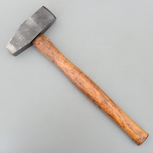 Peut inclure: Un marteau en métal avec une tête rectangulaire et un manche en bois. La tête du marteau est de couleur gris foncé et le manche est de couleur marron clair. Le marteau est conçu pour les travaux de construction et de réparation.