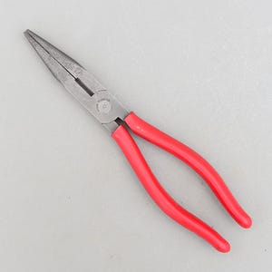 May include: Needle-nose pliers with red handles and a silver finish. The handles are marked with the text "CHINA STAINLESS".
