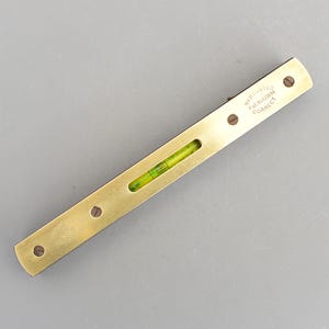 以下が含まれることがあります： 緑色の水準器と「WARRANTED CORRECT Pat. No. 42389」という文字が刻まれた真鍮製のレベルです。