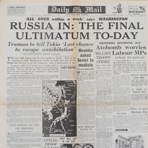 Peut inclure: Une page de journal vintage en noir et blanc du 9 août 1945, avec le titre « RUSSIA IN: THE FINAL ULTIMATUM TO-DAY ». L'article traite de la guerre avec le Japon, de la bombe atomique et des rôles de Truman et Hirohito. Une carte de la région est incluse.