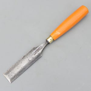 Può includere: Uno scalpello con manico arancione brillante e lama in acciaio. La lama reca la scritta "I. SORBY CAST STEEL". Utensile manuale per la lavorazione del legno e altri progetti artigianali.