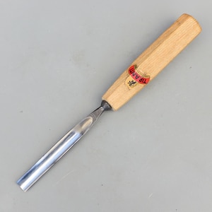 以下が含まれることがあります： 黒い持ち手と「But First, Coffee」のテキストが太字の黒いフォントで書かれた白いセラミックマグ。マグカップはニュートラルな背景に置かれ、シンプルなデザインを際立たせています。