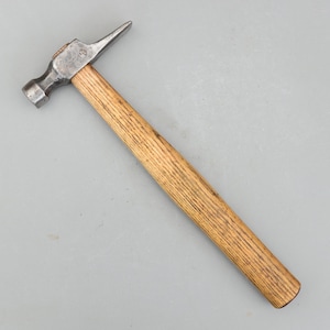 May include: A claw hammer with a wooden handle and a metal head. The hammer head has a flat face on one side and a claw on the other. The handle is made of light brown wood.