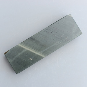 May include: A rectangular green sharpening stone with a light grey streak running through it.