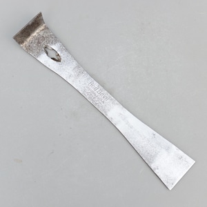 May include: A silver-colored Red Devil putty knife with a curved blade and a small oval hole. The text "Red Devil UNION, N.J. U.S.A. 4050" is stamped on the handle. The tool is designed for scraping and spreading.