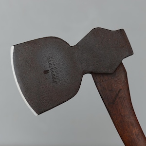May include: Close-up of a vintage axe with a dark, weathered metal head and a wooden handle. The axe head has a white edge and the text "S.B. & CO. BLUE RIDGE" is visible. The handle is a dark brown color.