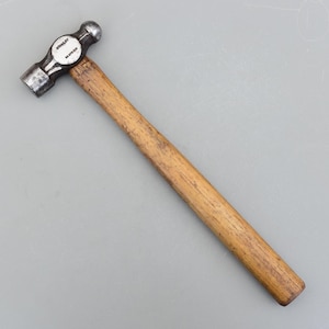 以下が含まれることがあります： 木製の柄が付いたボールピンハンマー。 ハンマーヘッドは銀色で、「STANLEY」の文字が印刷されています。 柄は木製で、明るい茶色です。