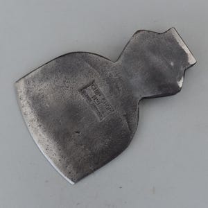 Op de afbeelding: Een vintage stalen bijlkop met een gebogen blad en een getextureerde, donkergrijze afwerking. De bijlkop heeft de tekst "CHIP CHOP No. 1" gestempeld op het oppervlak. De bijlkop is ontworpen voor het hakken en splijten van hout.