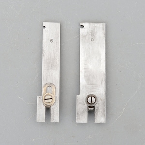 Peut inclure: Deux outils en métal avec les numéros 6 et 15 imprimés dessus. Les outils ont une vis et une petite boucle sur le dessus.