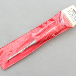 Könnte beinhalten: Ein roter und silberner 1,27 cm Holzmeißel in einer durchsichtigen Plastikverpackung mit einem weißen Etikett mit der Aufschrift "Footprint 1/2 in. WOOD CHISEL Made in England.  Guaranteed for Life.  No. 12"