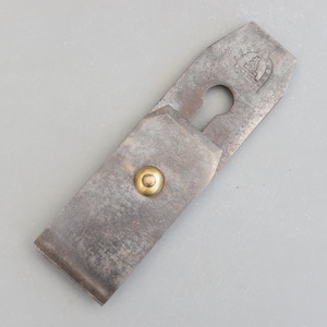 以下が含まれることがあります： 真鍮のネジと鍵穴型の開口部が付いた、ヴィンテージの金属製手鉋。 ツールは、使用の兆候が見られる、摩耗した、経年変化した外観をしています。 小さなエンブレムが上部に刻印されています。 この木工工具は、木材の表面を成形および平滑化するように設計されています。