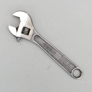 Peut inclure: Une clé à molette argentée de 15,24 cm de long, avec l'inscription "JACKDAW MADE IN ENGLAND" gravée sur le manche. La clé a une mâchoire réglable et un trou circulaire à l'extrémité du manche.