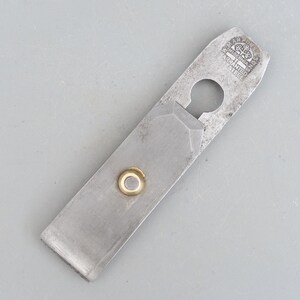 May include: A silver metal hand plane with a brass screw and a hole in the handle. The plane is marked "CARPENTER'S TOOLS,  WARRANTED STEEL".