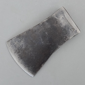 May include: A dark grey metal axe head with a curved cutting edge and a flat poll. The surface shows signs of wear and oxidation. Stamped text on the side reads: JAMES SILCOCK LTD, DRONFIELD, 1944, with a triangular logo featuring an arrow symbol.