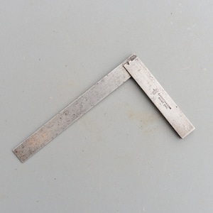 May include: A silver metal try square with the text "E.K.H.STONECROFT BIRMINGHAM ENG." on the short side.