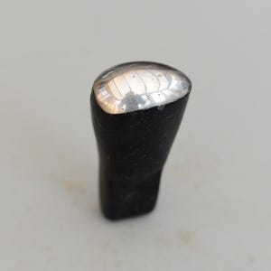 以下が含まれることがあります： 銀色の頭部を持つ黒い金属製のハンマー。ハンマーは金属を成形するために使用されます。