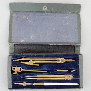 Peut inclure: Un ensemble d'instruments de dessin en laiton dans un étui doublé de velours vert. Les outils comprennent un compas, un diviseur et un crayon. Les outils sont tous en excellent état.