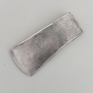 Peut inclure: Un ciseau à bois rectangulaire en métal, avec un bord tranchant légèrement incurvé. Le ciseau présente une finition argentée usée et le texte "MARSHALL & FIE" est estampé sur le dessus. Outil de menuiserie.