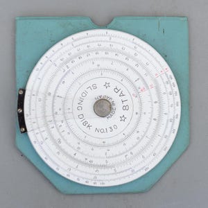 May include: A vintage Star Sliding Disk calculator, model No. 130, made in Japan. The circular calculator features white markings on a white background, with a blue backing. The calculator has a metal center and is designed for mathematical calculations.