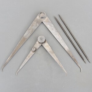 Puede incluir: Dos compases de dibujo de metal plateado y dos agujas de dibujo de metal plateado. Los compases tienen un botón de ajuste de metal plateado.