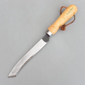 May include: A gardening knife with a wooden handle and a curved, stainless steel blade. The handle is light-coloured wood with the text "Burgon & Ball" printed on it. A leather loop is attached to the handle.
