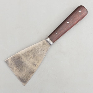 May include: A metal putty knife with a dark brown wooden handle secured by three rivets. The wide, flat, trapezoidal steel blade shows signs of wear and features the stamped text W. WRIGHT & SONS LTD LYMM and the number 169 in a circle.