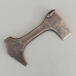 May include: A vintage, weathered metal tool with a unique shape. The tool has a small axe-like head on one end, a pointed tip on the other, and a curved handle. The text "MEADVILLE PA USA" is stamped on the handle.