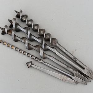 Może przedstawiać: Zestaw pięciu antycznych wierteł ze skręconym wzorem metalowym. Wiertła są wykonane z metalu i mają srebrny kolor.