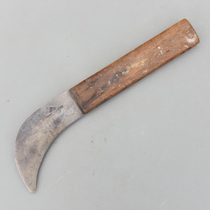 Puede incluir: Un cuchillo de hoja curva con mango de madera. La hoja es de metal y tiene forma curva. El mango es de madera y rectangular. El cuchillo tiene el texto "MARPLES & SONS" en la hoja.